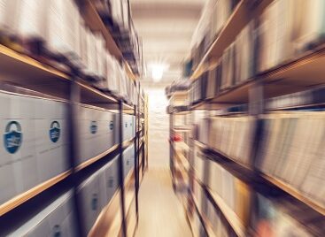 Shelves full of paper documents stored in an old archive. Radial zoom effect defocusing filter applied, with vintage instagram look.